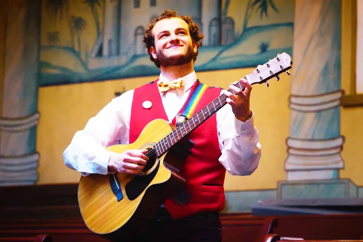 Community Creative Fellow plays guitar for a crowd at a Greater Boston synagogue