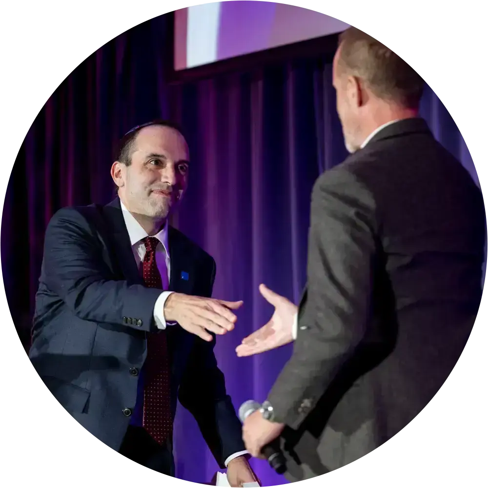 Two professionals shaking hands to represent employer matching gifts that help you donate to Jewish causes in Boston and double your impact in the Greater Boston community.