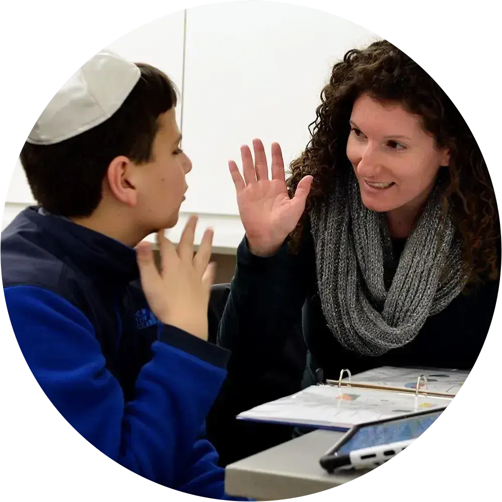 Teacher high-fiving a young Jewish student in an inclusive learning environment.