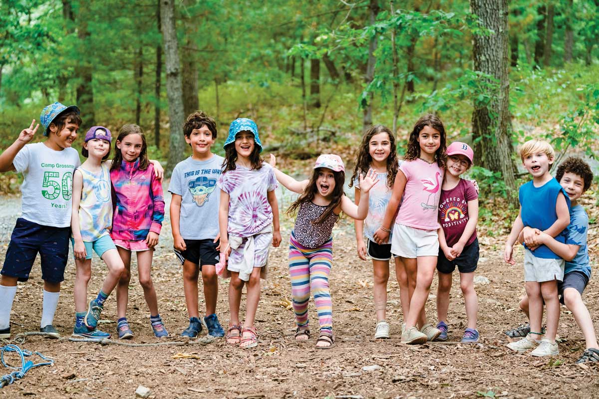 Jewish life Boston Jewish summer camps with children walking together through the woods, smiling and enjoying outdoor activities that build friendship and community in Greater Boston.